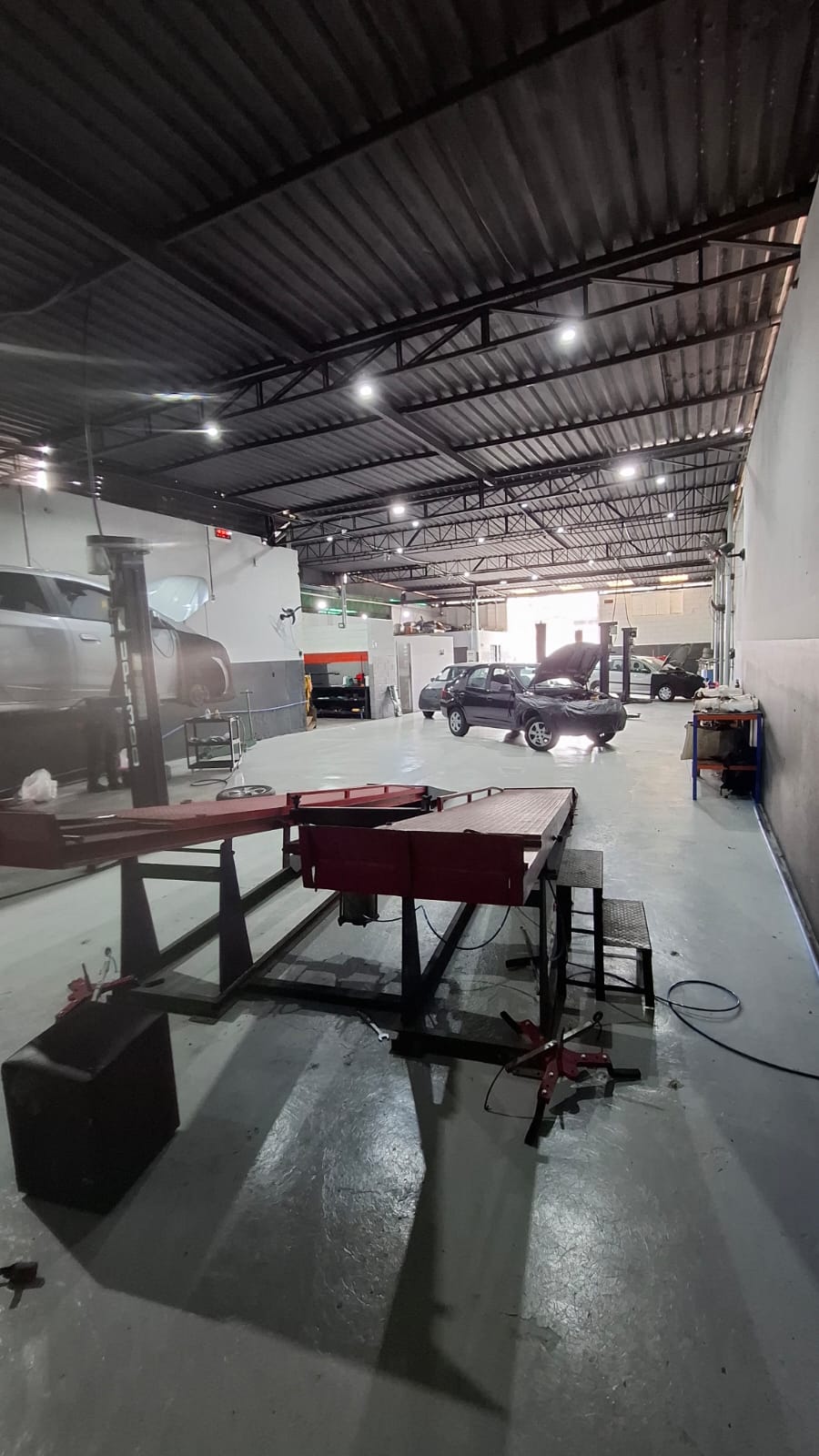 Interior da oficina Senna com veículos em manutenção e elevadores